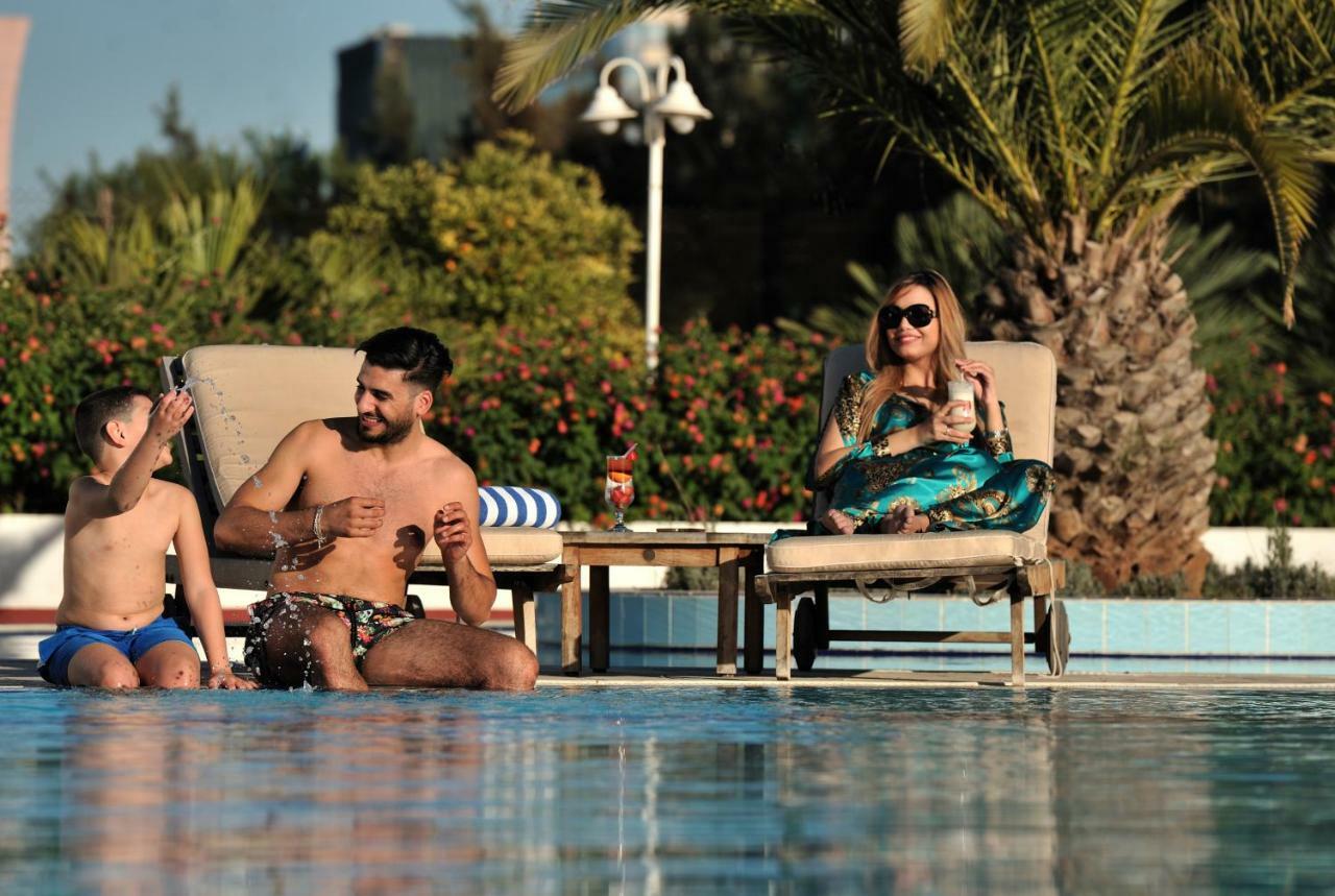 グランド ホテル メルキュール アルジェ エアロポート Dar el Beïda エクステリア 写真 A family at a pool in Dubai