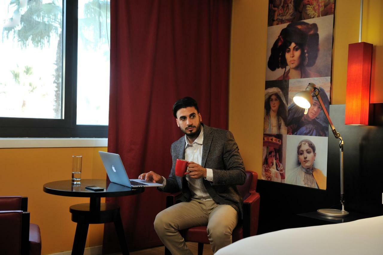 グランド ホテル メルキュール アルジェ エアロポート Dar el Beïda エクステリア 写真 A man working on a laptop